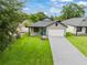 Aerial view of a single Gathering home with a gray roof, brick driveway, and a well-manicured lawn at 1113 Naples Dr, Orlando, FL 32804