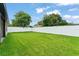 Expansive, well-manicured backyard with lush green grass and a white privacy fence at 1113 Naples Dr, Orlando, FL 32804