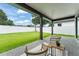 Inviting covered patio with seating, overlooking a large, green backyard and privacy fence at 1113 Naples Dr, Orlando, FL 32804
