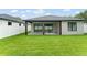 Wide view of a covered patio and expansive lawn of a modern home, enclosed by a white privacy fence at 1113 Naples Dr, Orlando, FL 32804