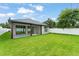 Spacious backyard with a covered patio, green lawn, and modern home exterior at 1113 Naples Dr, Orlando, FL 32804