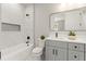 Bright bathroom featuring marble-tiled shower, gray vanity and a stylish framed mirror at 1113 Naples Dr, Orlando, FL 32804