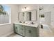 Well-lit bathroom featuring a double sink vanity, large mirror, and modern fixtures at 1113 Naples Dr, Orlando, FL 32804