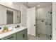 Modern bathroom featuring a green vanity, quartz countertop, and a glass-enclosed shower with tiled walls at 1113 Naples Dr, Orlando, FL 32804