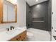 Stylish bathroom featuring dark tiled shower, wood vanity, and modern fixtures at 1113 Naples Dr, Orlando, FL 32804