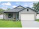 Charming single Gathering home featuring a well-manicured lawn, gray siding, and a front-facing two car garage at 1113 Naples Dr, Orlando, FL 32804