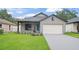 Charming single Gathering home featuring a well-manicured lawn, gray siding, and a front-facing two car garage at 1113 Naples Dr, Orlando, FL 32804