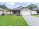 Charming single Gathering home featuring a well-manicured lawn, gray siding, and a front-facing two car garage at 1113 Naples Dr, Orlando, FL 32804