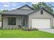 Charming single-story home featuring board and batten siding, a blue door and an attached garage at 1113 Naples Dr, Orlando, FL 32804
