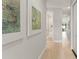 Bright hallway with light wood flooring and modern artwork, leading to other rooms in the home at 1113 Naples Dr, Orlando, FL 32804