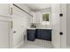 Well-lit laundry room with blue cabinets, white countertops, and stylish patterned flooring at 1113 Naples Dr, Orlando, FL 32804