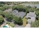An aerial view showcasing a beautiful home with a screened pool surrounded by lush landscaping at 11721 Camden Park Dr, Windermere, FL 34786