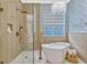 Luxurious bathroom with a soaking tub, glass-enclosed shower, and stylish fixtures at 11721 Camden Park Dr, Windermere, FL 34786