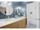Elegant bathroom featuring double sinks, gold hardware, and a blue floral accent wall at 11721 Camden Park Dr, Windermere, FL 34786