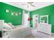 Bright bedroom featuring white furniture, a ceiling fan, and a vibrant green accent wall at 11721 Camden Park Dr, Windermere, FL 34786