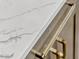 Close-up of a luxurious white marble countertop with stylish gold hardware on modern cabinetry at 11721 Camden Park Dr, Windermere, FL 34786