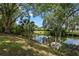 Enjoy backyard views of the pond from the fenced-in yard shaded by mature trees at 120 Springwood Trl, Altamonte Springs, FL 32714