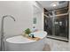 Modern bathroom featuring a soaking tub with wood caddy, a glass-enclosed shower, and marble-like tile at 120 Springwood Trl, Altamonte Springs, FL 32714