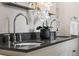 Close-up of bathroom double vanity featuring dark counters and a modern sink with chrome fixtures at 120 Springwood Trl, Altamonte Springs, FL 32714
