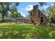 Backyard with a large brick chimney, screened-in pool, and a lush green lawn at 120 Springwood Trl, Altamonte Springs, FL 32714