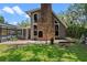 An exterior view of the home, showing a brick chimney, paved patio and tall windows at 120 Springwood Trl, Altamonte Springs, FL 32714