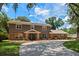 Charming two-story home features a brick and siding exterior, complemented by lush landscaping and a circular driveway at 120 Springwood Trl, Altamonte Springs, FL 32714