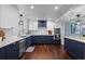 Well-lit kitchen featuring white upper cabinets and navy blue lower cabinets at 120 Springwood Trl, Altamonte Springs, FL 32714