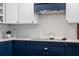 Stylish kitchen features a hexagon tile backsplash, blue lower cabinets, and modern appliances at 120 Springwood Trl, Altamonte Springs, FL 32714