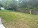 Large backyard with a mix of grass and a wooden fence at 1241 Cleveland Ave, Apopka, FL 32703
