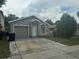 Single-story home with grey exterior paint, a one-car garage, and landscaping at 1241 Cleveland Ave, Apopka, FL 32703