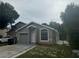 Charming single-story home with a gray exterior, updated landscaping, and an attached one-car garage at 1241 Cleveland Ave, Apopka, FL 32703