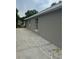Neutral painted block house with updated windows and a paved area at 1241 Cleveland Ave, Apopka, FL 32703