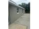 Neutral colored exterior showing replacement windows and access to the backyard at 1241 Cleveland Ave, Apopka, FL 32703