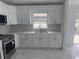 Kitchen with white cabinets, stainless steel appliances, quartz countertops, and marble-look tile flooring at 1241 Cleveland Ave, Apopka, FL 32703