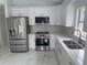 Bright, updated kitchen featuring stainless steel appliances, white cabinets, quartz countertops, and elegant tile flooring at 1241 Cleveland Ave, Apopka, FL 32703