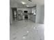 Bright, updated kitchen featuring stainless steel appliances, white cabinets, and elegant marble-look flooring at 1241 Cleveland Ave, Apopka, FL 32703