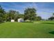 Expansive backyard with lush lawn, mature trees, and a storage shed at 1242 Liza St, St Cloud, FL 34771