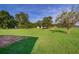 View of the home's sprawling fenced backyard with mature trees and a storage shed at 1242 Liza St, St Cloud, FL 34771