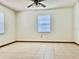Neutral-toned bedroom with a window, neutral tile floors, and baseboard trim at 1242 Liza St, St Cloud, FL 34771