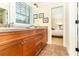 Bathroom featuring a dual sink vanity, framed mirrors, a tiled floor, and a glimpse into an adjacent bedroom at 1355 Hibiscus Ave, Winter Park, FL 32789