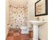 Charming bathroom featuring unique tiled shower, pedestal sink, and checkered flooring, blending style and functionality at 1355 Hibiscus Ave, Winter Park, FL 32789