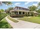 Two-story home with a covered porch, manicured landscaping, and a curved driveway at 1355 Hibiscus Ave, Winter Park, FL 32789