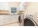 Well-equipped laundry room features a sink, ample cabinetry, and a convenient washer and dryer for easy chore completion at 1355 Hibiscus Ave, Winter Park, FL 32789