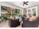 Relaxing screened-in patio featuring tile flooring, a ceiling fan, and comfortable seating overlooking the pool area at 1355 Hibiscus Ave, Winter Park, FL 32789