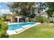 Inviting backyard pool surrounded by lush greenery, complemented by an umbrella and screened-in lanai at 1355 Hibiscus Ave, Winter Park, FL 32789