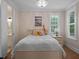 Bedroom with a bed, side tables, decoratove items, and bright windows with wooden floors at 1438 Stickley Ave, Celebration, FL 34747