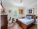 Cozy bedroom with a wooden bed frame, hardwood floors, and a decorated desk area at 1438 Stickley Ave, Celebration, FL 34747