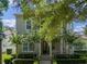 Charming two-story home with a covered porch and balcony surrounded by mature trees and manicured landscaping at 1438 Stickley Ave, Celebration, FL 34747