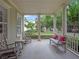 Relaxing front porch featuring rocking chairs, a bench with pillows, and classic columns at 1438 Stickley Ave, Celebration, FL 34747