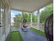 Covered porch featuring a golf putting green with hanging chairs and decorative columns at 1438 Stickley Ave, Celebration, FL 34747